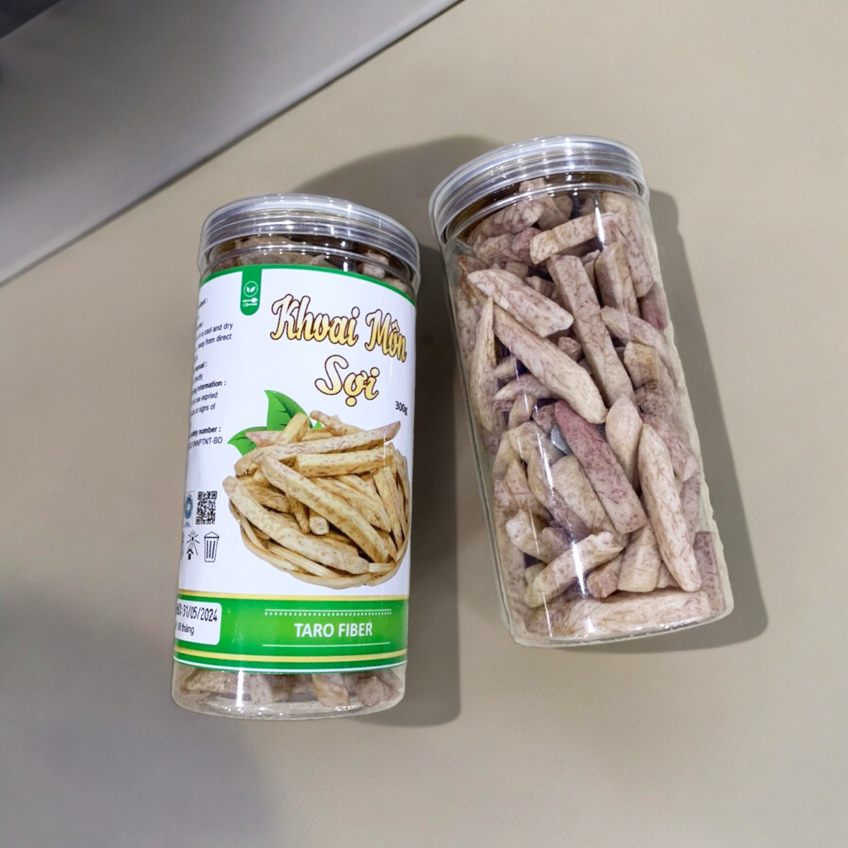 24446_z5494823637098-4b72a29f1ad790f6387e42ad263287c9-photoroom_20240601123645-1.png Khoai Môn Sấy Sợi Cộng Giòn 300g - 8936208930929